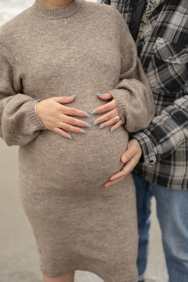 Close up of pregnant woman holding baby belly during a maternity photoshoot.