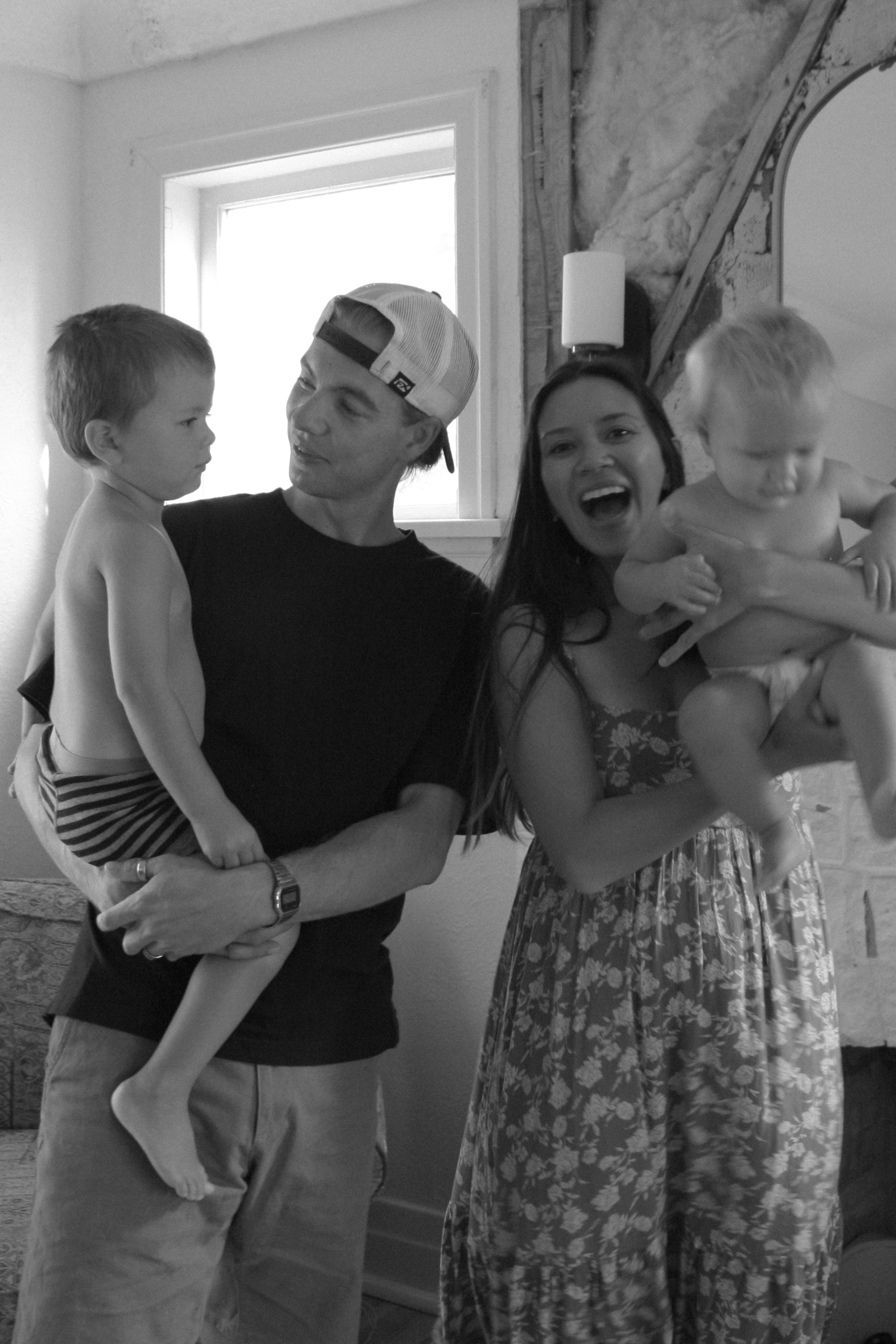 black and white image of family with two sons, laughing and enjoying time together - Family Photography