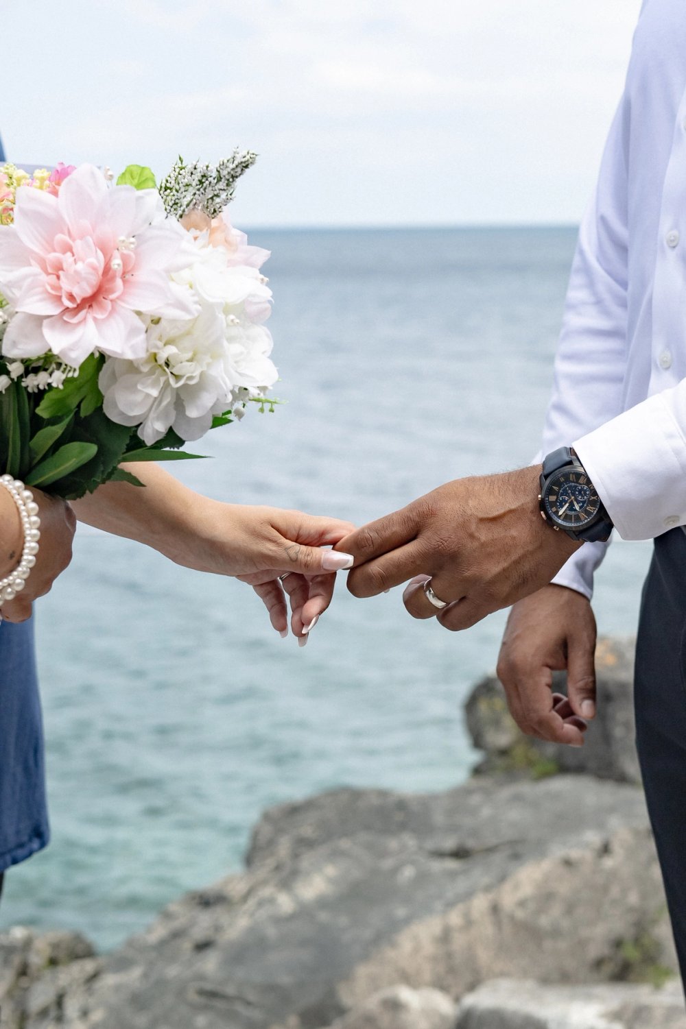 two hands holding each other by the pointing and middle finger - Tobermory Elopement Photography