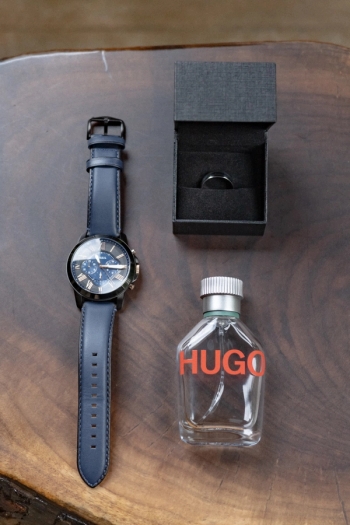 watch, engagement ring and cologne bottle laid out on wooden surface - Tobermory Elopement Photography