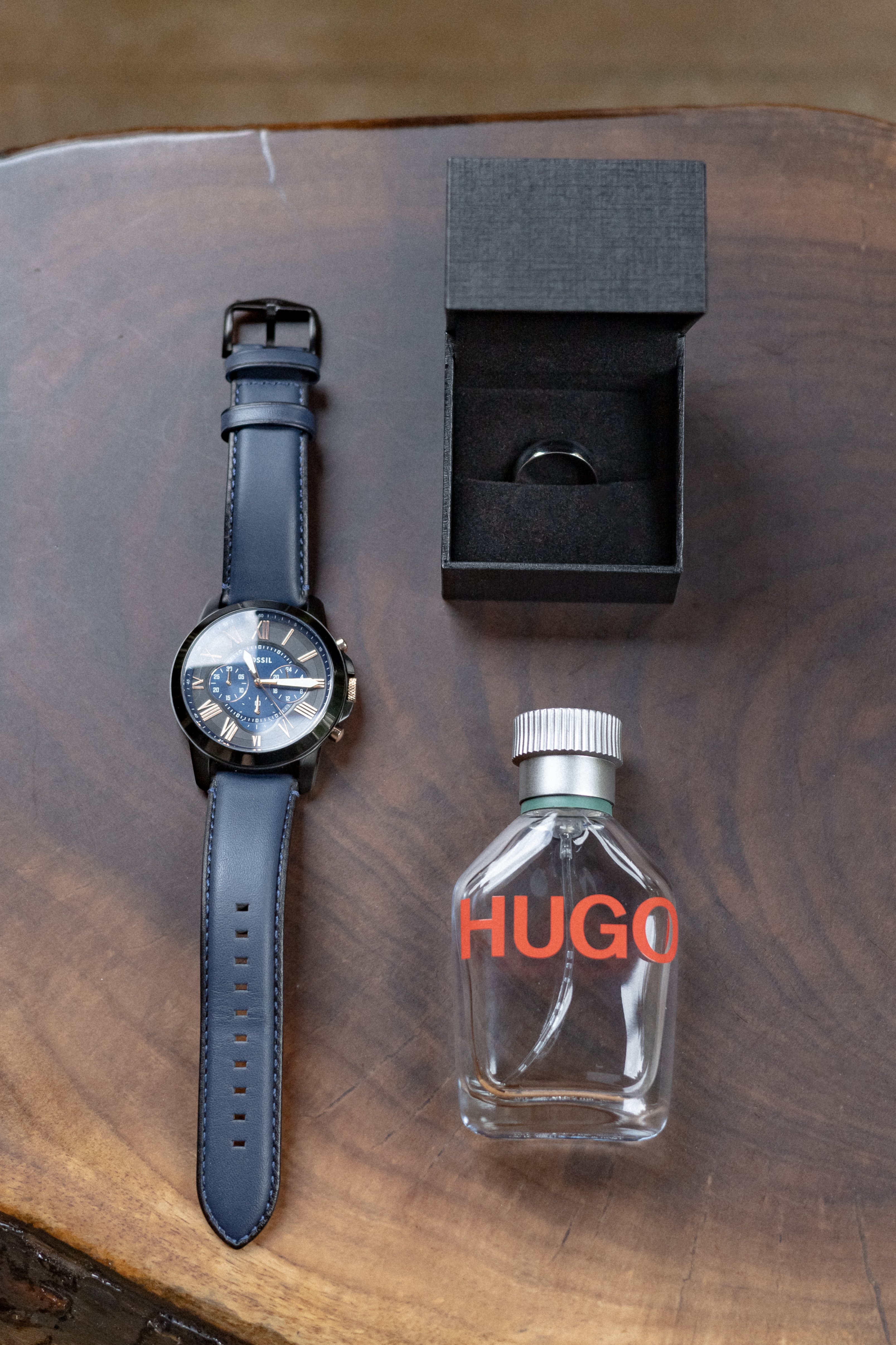 watch, engagement ring and cologne bottle laid out on wooden surface - Tobermory Elopement Photography