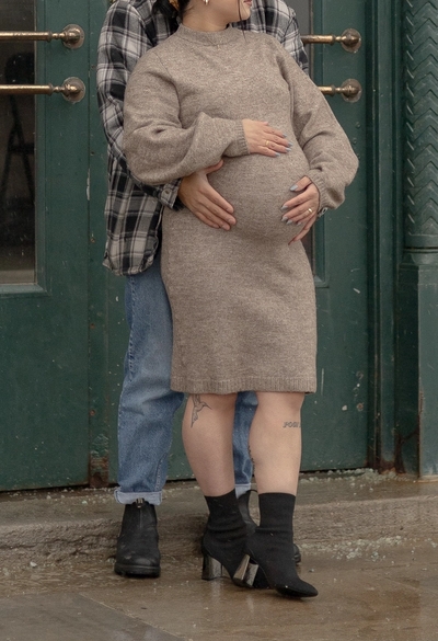 Maternity photos in front of green door, dad standing behind mom holding baby bump - Toronto Maternity Photography
