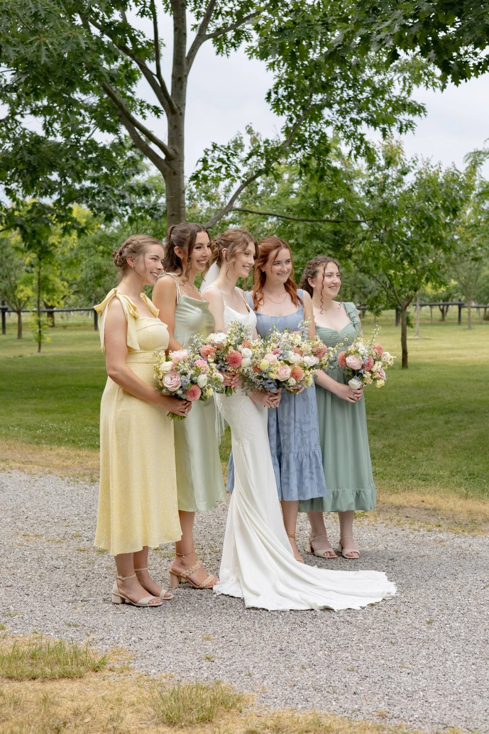 Bride and bridesmaids in pastel dresses during wedding portraits