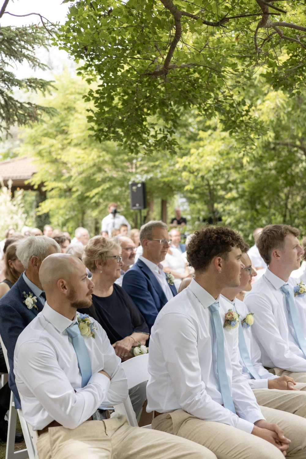 groomsmen seated watching couple say vows at wedding ceremony