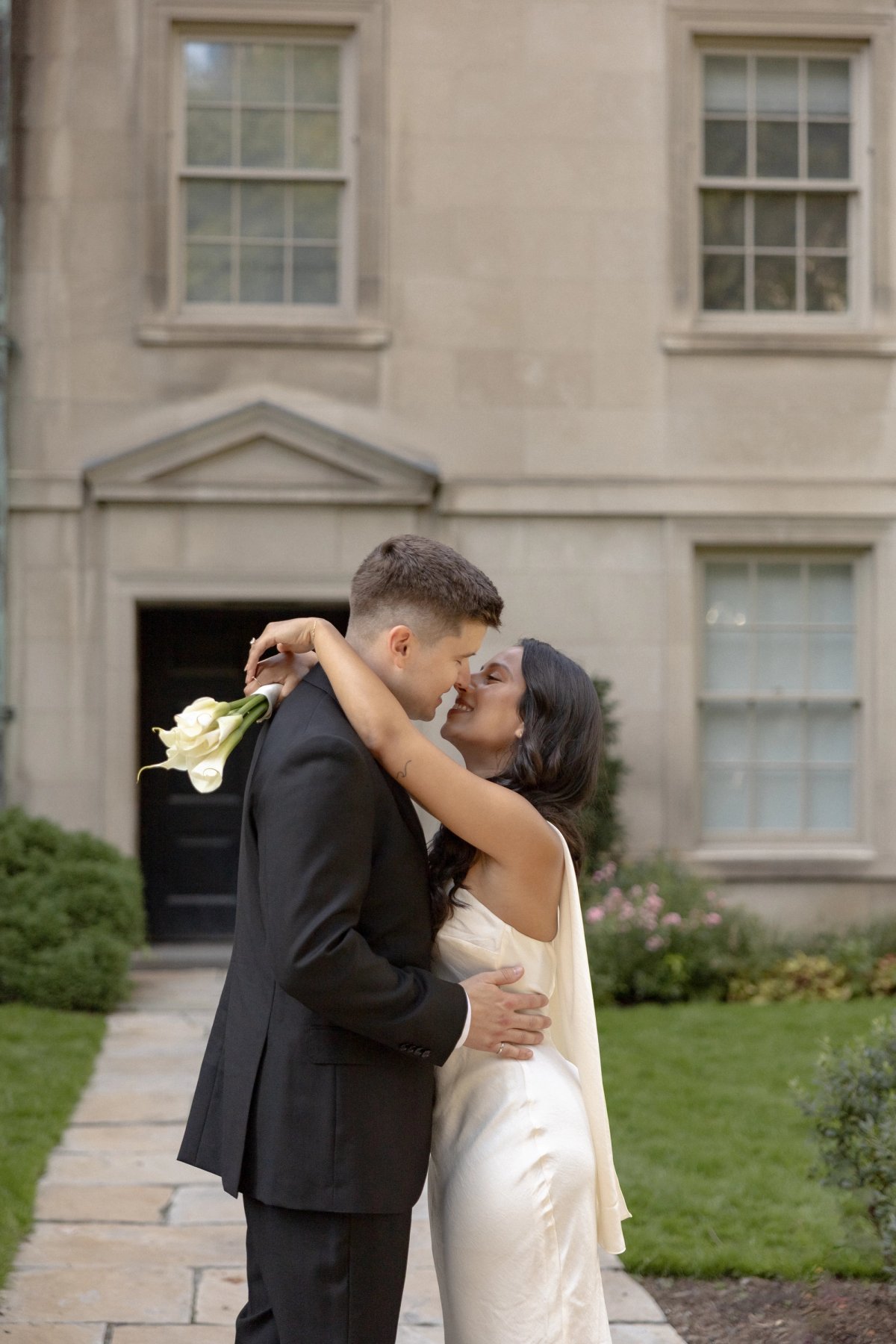 couple with arms around each other at osgoode hall before toronto city hall wedding 