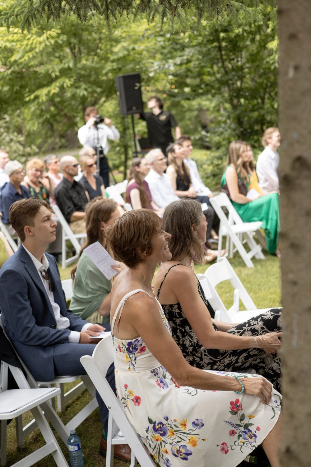 Wedding guests smiling during outdoor summer wedding ceremony