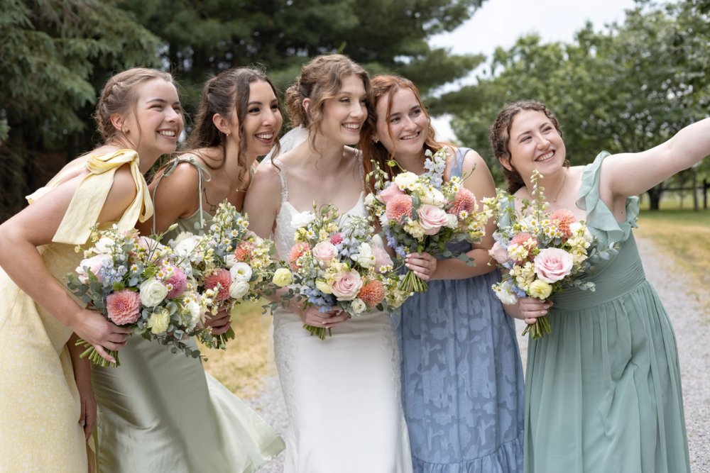 Bride with bridesmaids in soft pastel summer dresses at Niagara wedding