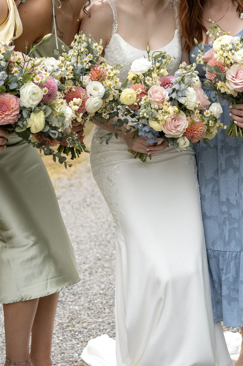 close up of colourful bridesmaid dresses and bouquets during summer wedding in niagara, ontario