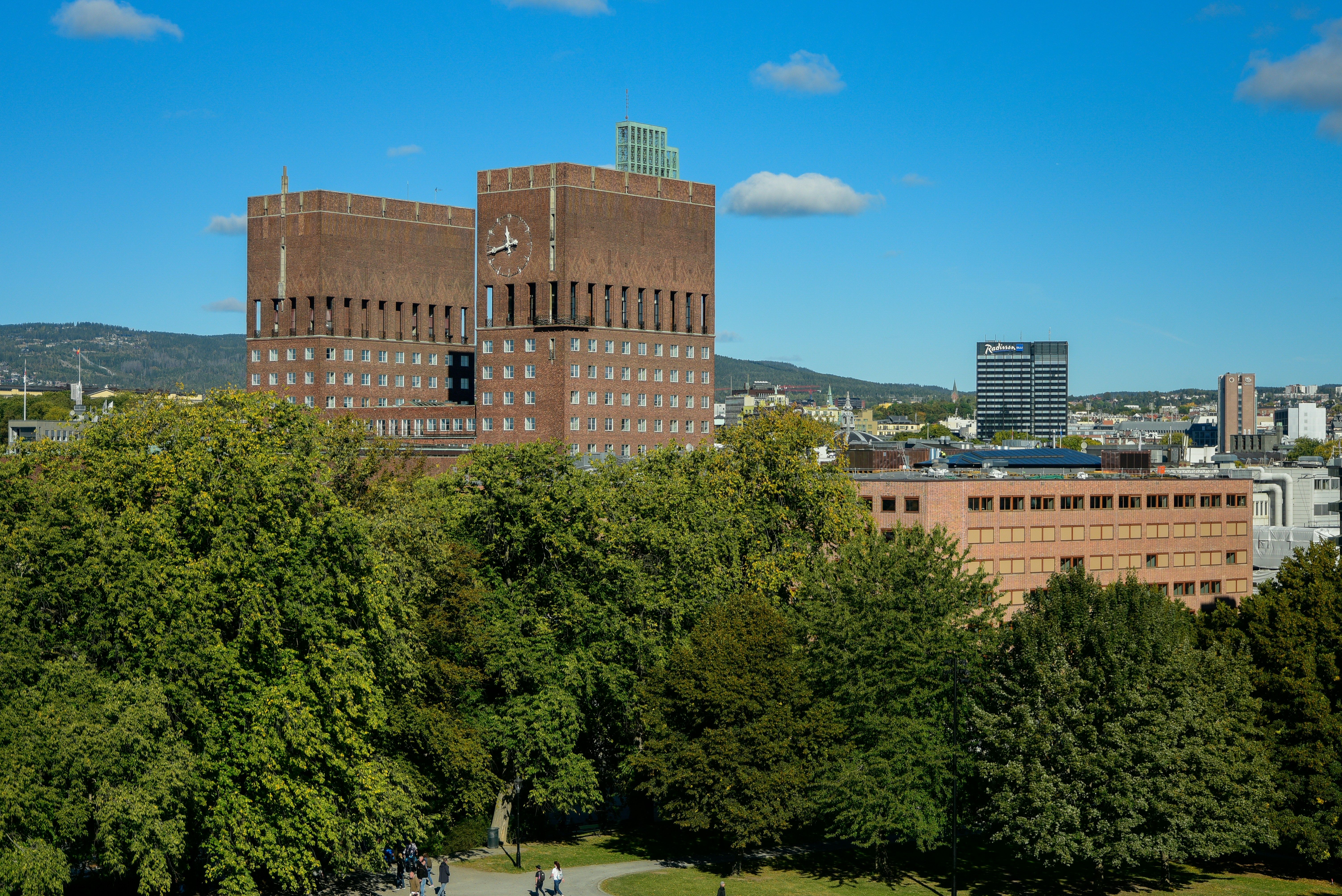 Oslo rådhus med trær og bybebyggelse rundt.