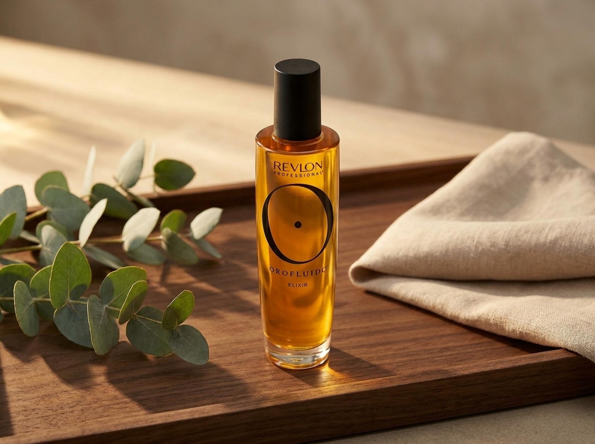 Revlon Professional Orofluido Elixir auf einem dunklen Holztablett mit frischen Eukalyptus-Zweigen