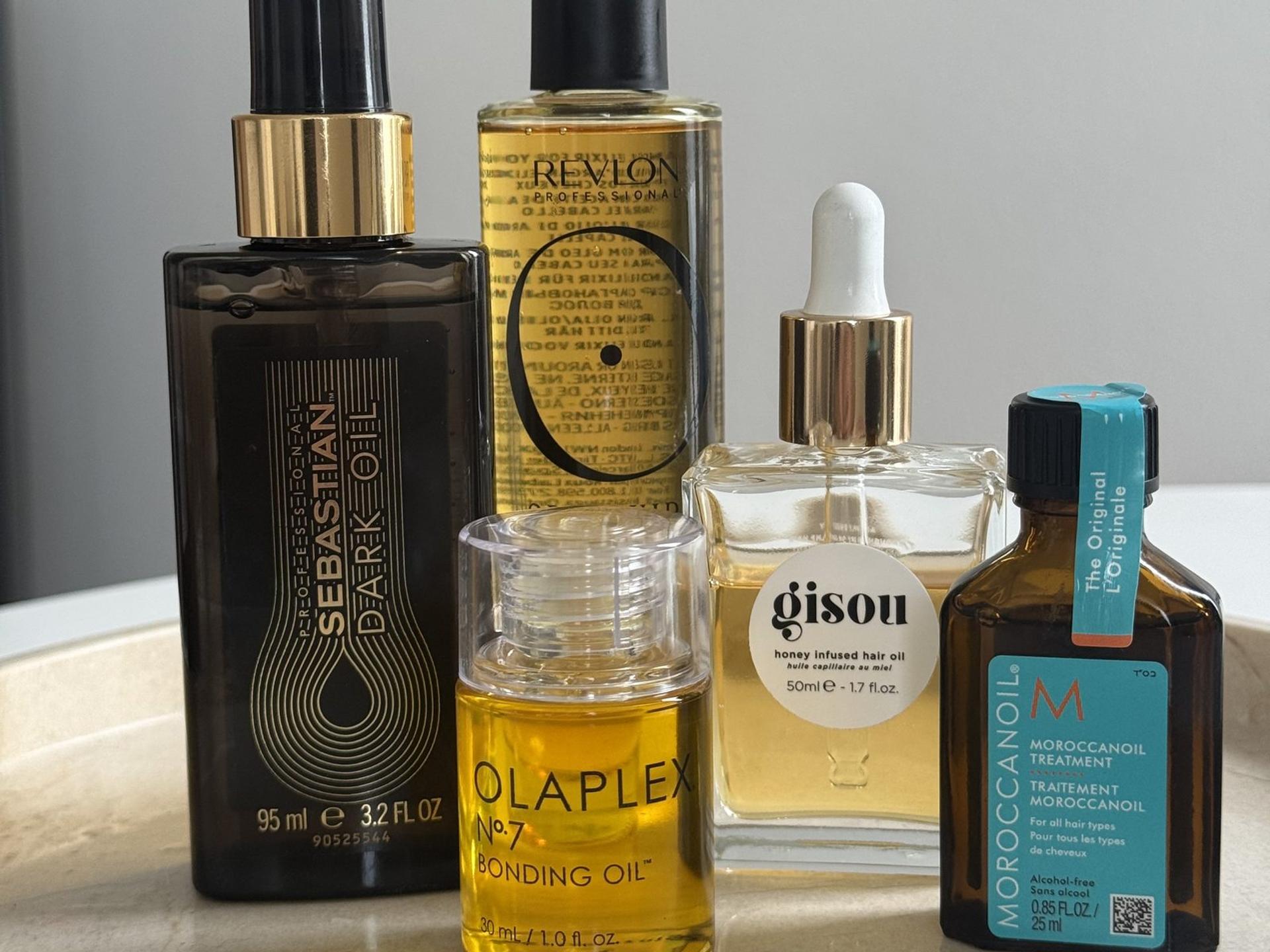 Unser Haaröl-Praxistest: fünf selbst angewendete Öle nebeneinander, darunter Testsieger Revlon Orofluido und Moroccanoil