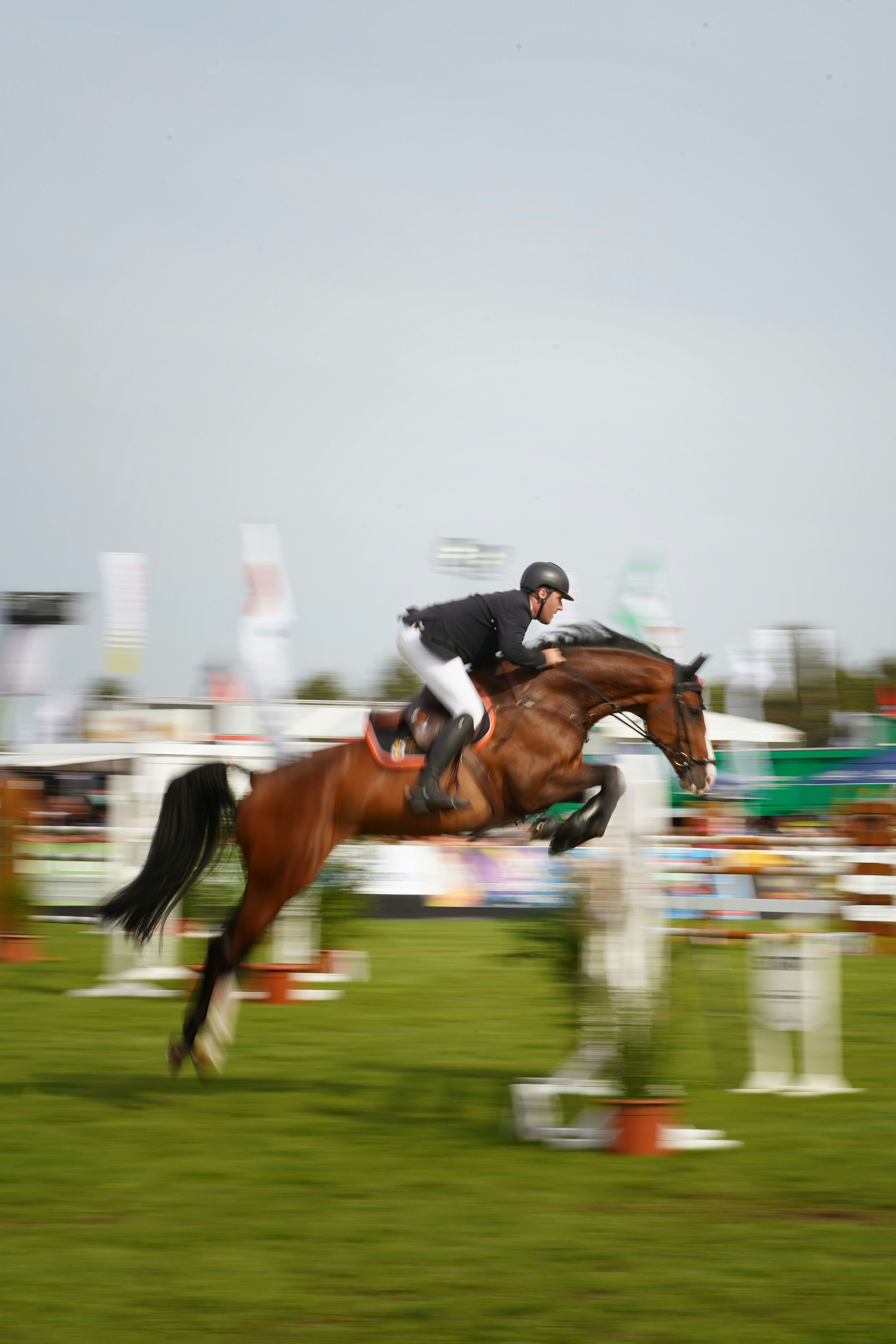 A horse and rider over a fence at an outdoor show