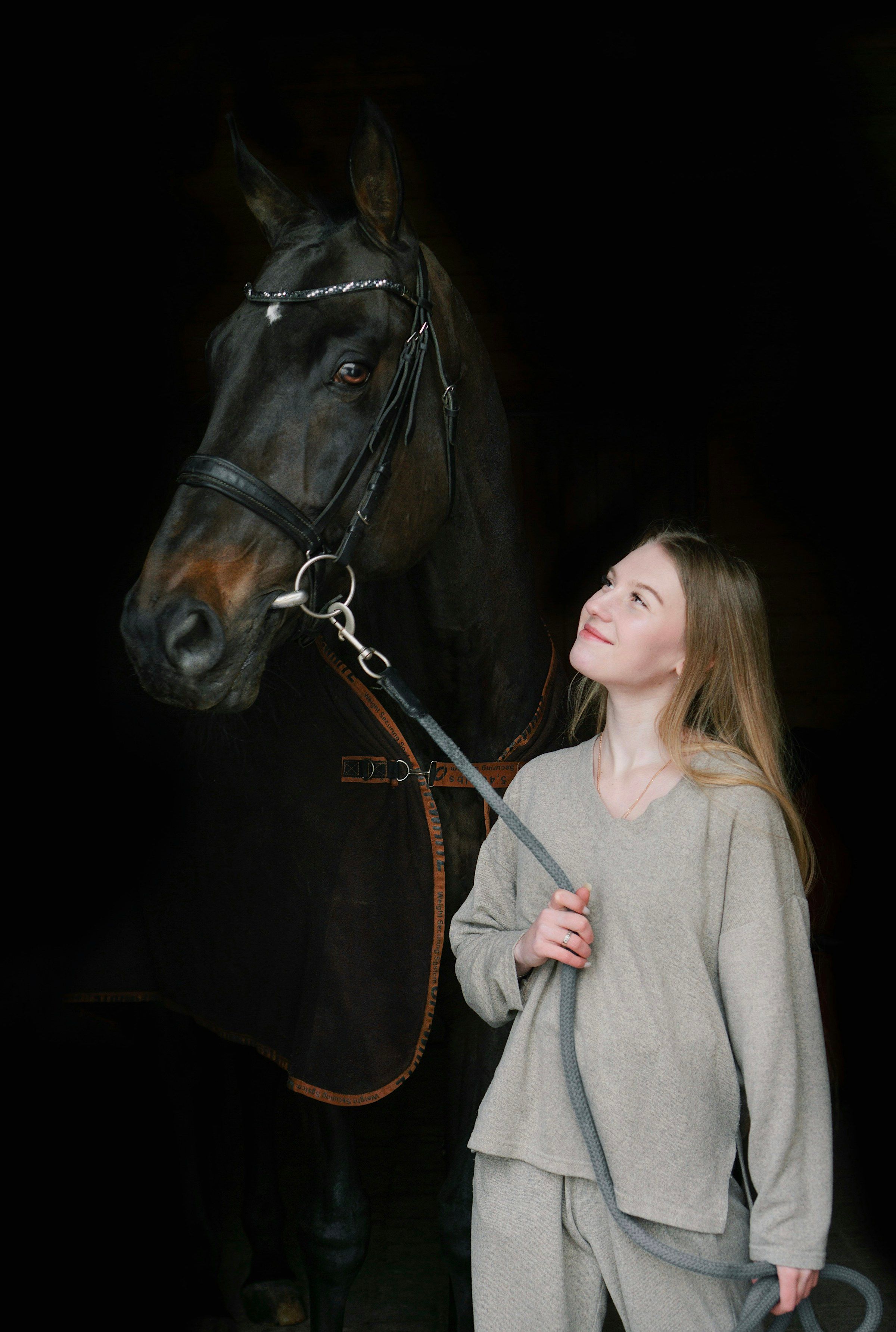 Hélène Duroc standing beside a black horse