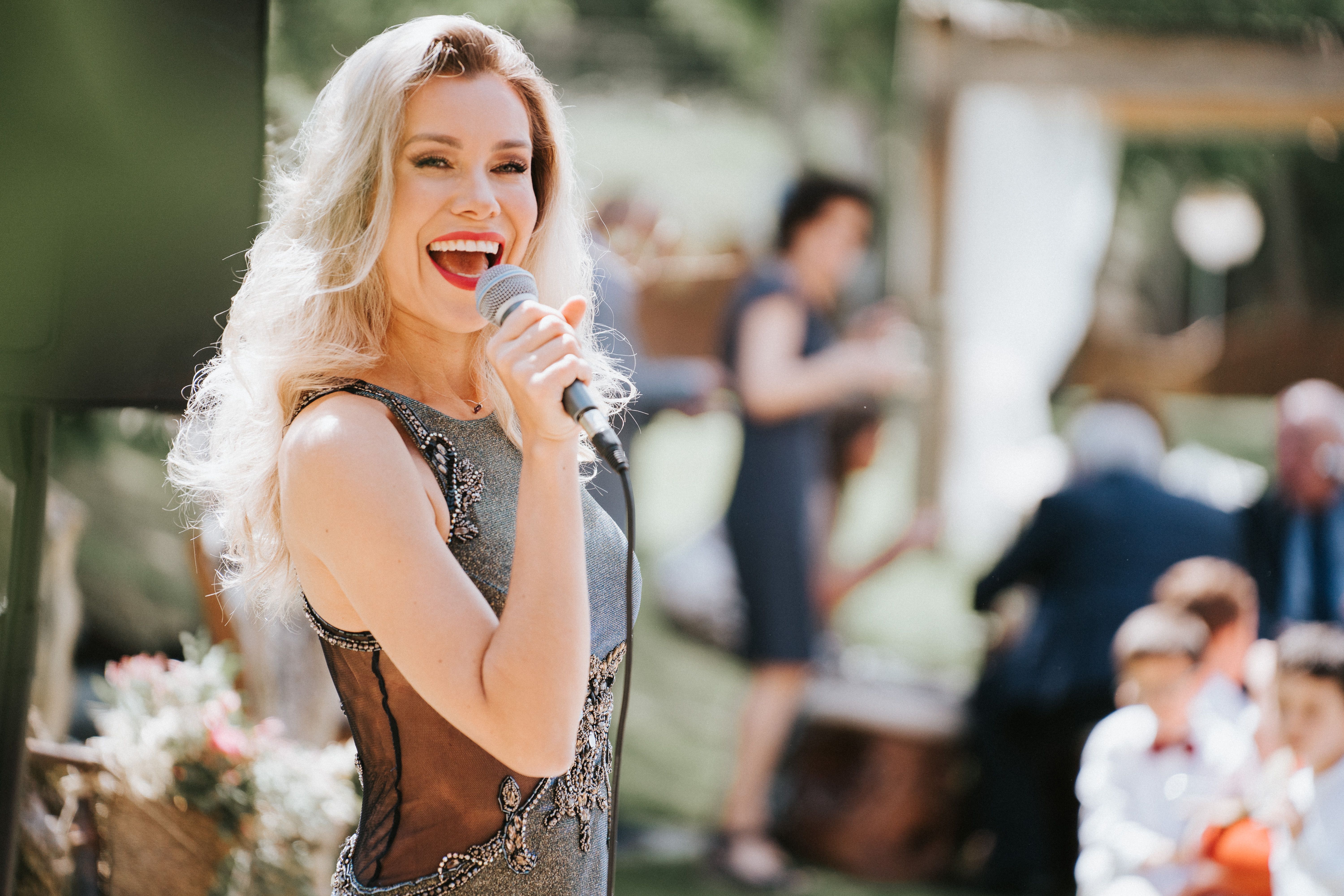 Marina Caró singing among wedding guests