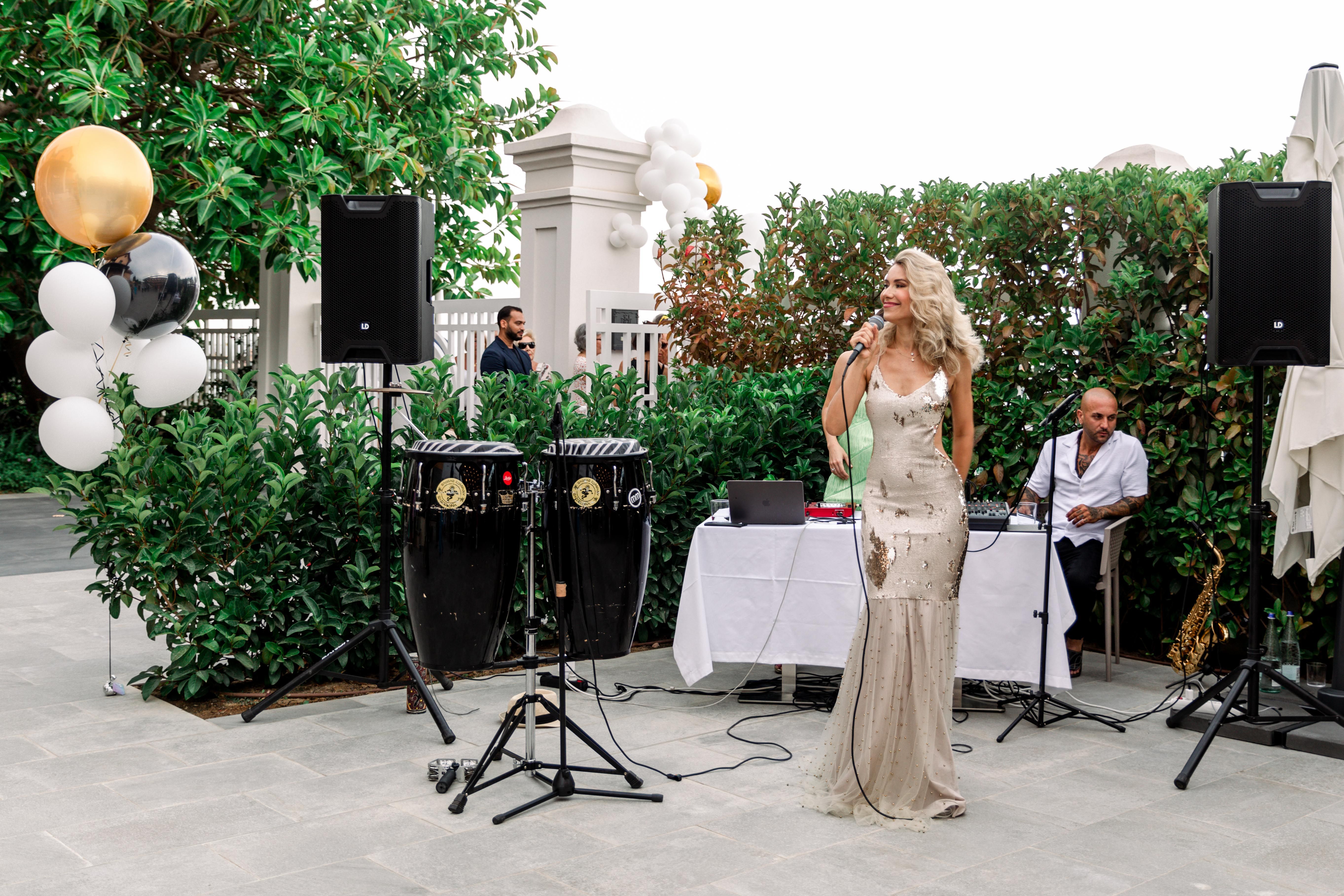 Singer performing outdoors beside percussion instruments