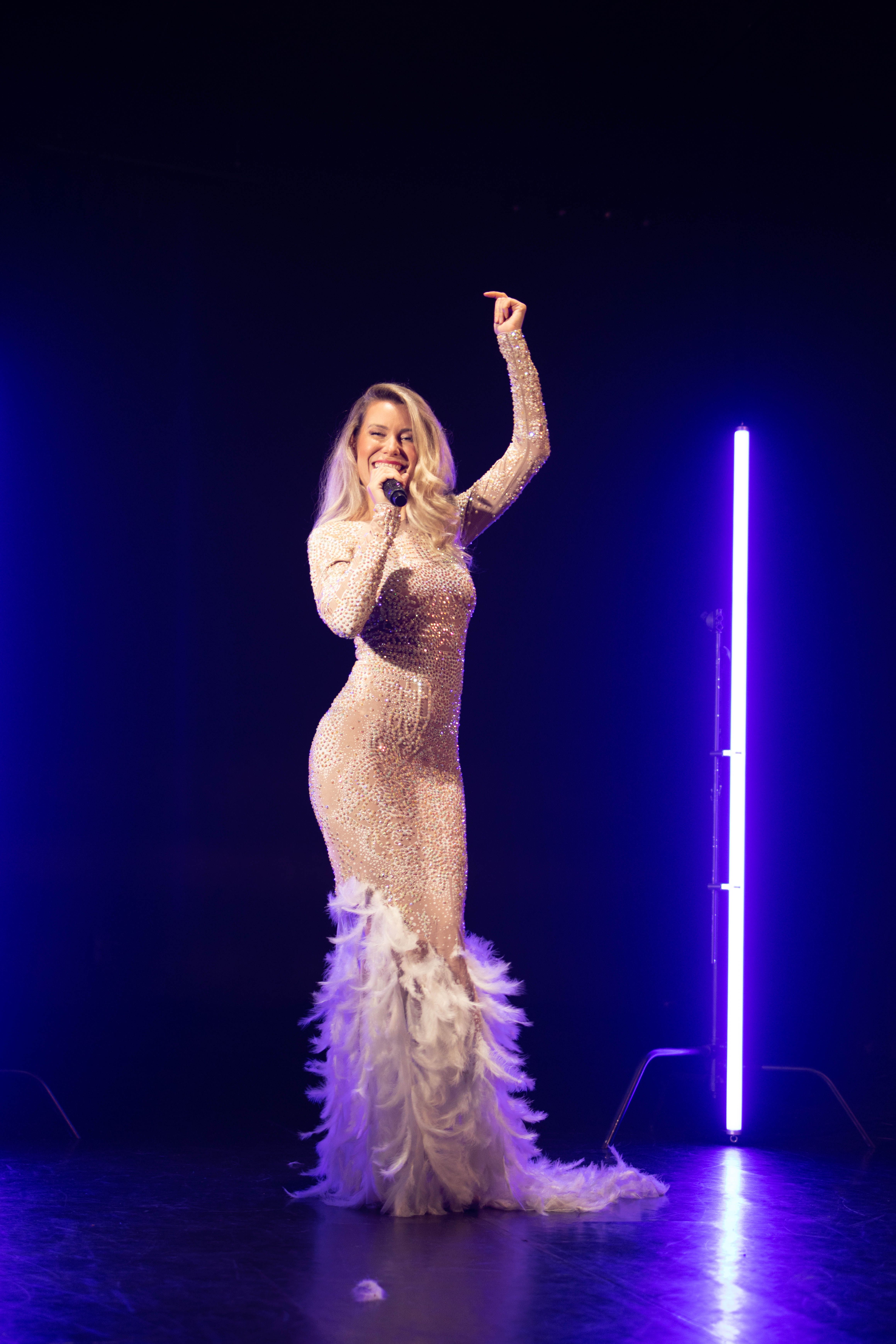 Singer performing with a microphone on an illuminated stage