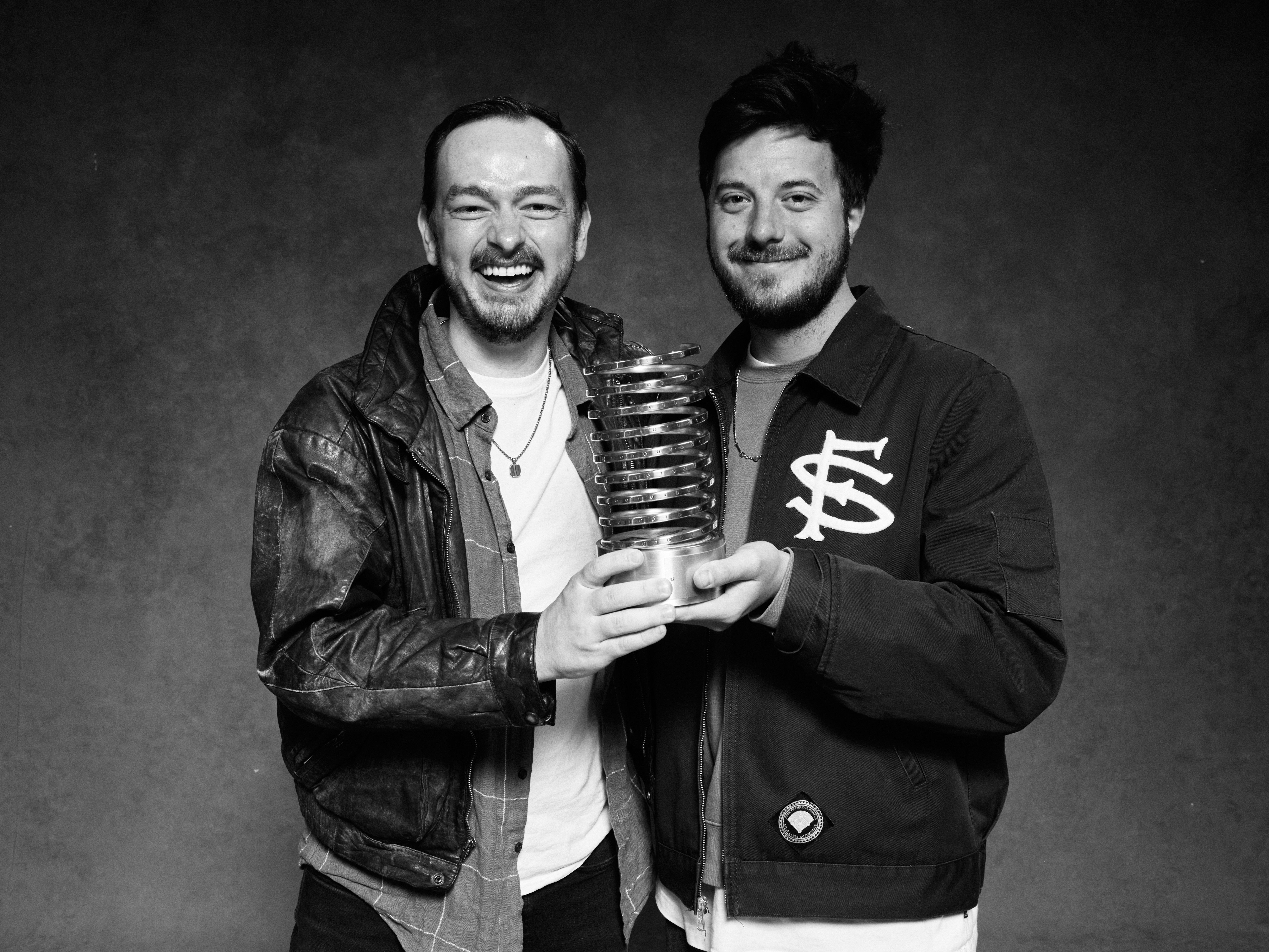 Trey, Domaine's VP Creative and Joel, Sr Designer at Domaine are holding a Webby Award in this black and white photograph.