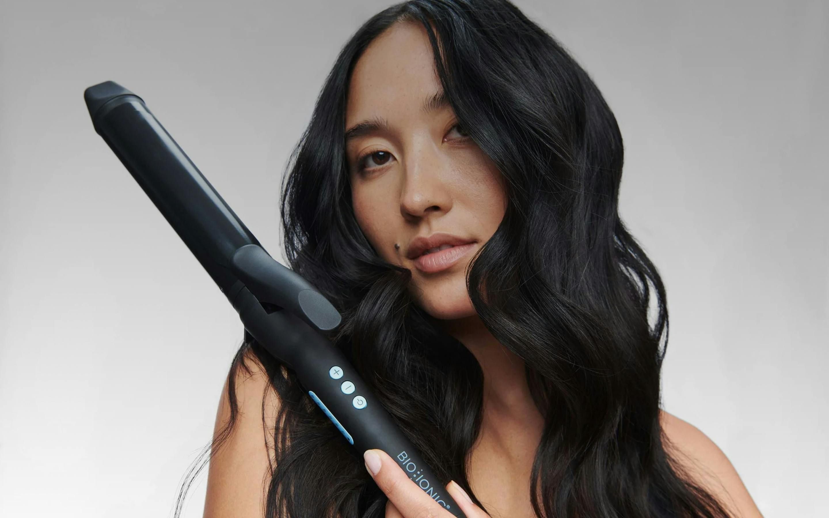 Woman with curly hair holds her BioIonic curler