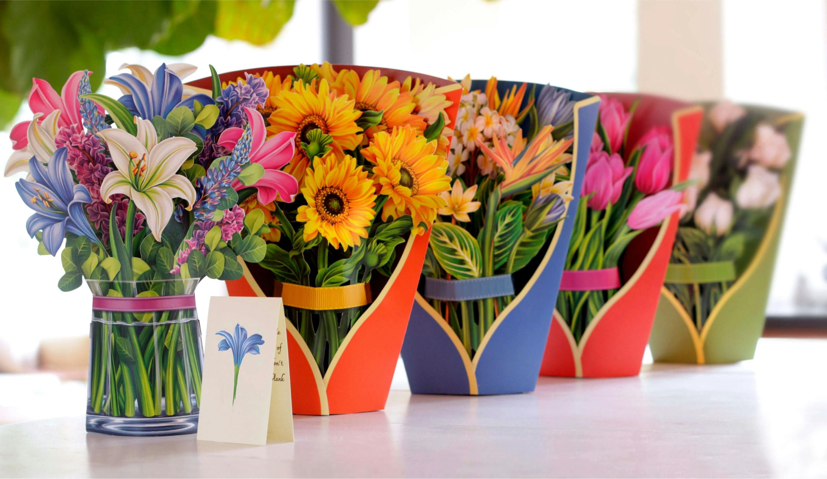 Several Fresh Cut Paper bouquets sitting on a table