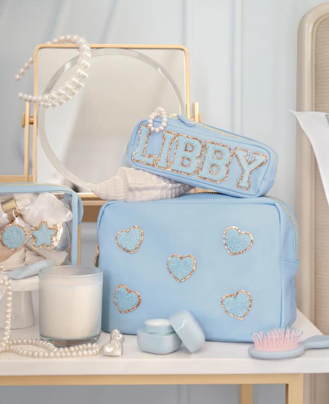 Various Stoney Clover Lane products piled on a vanity with monogramming reading 'Libby'