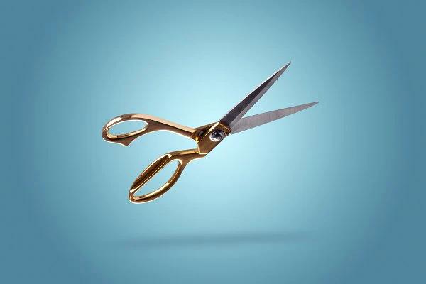 Photo of floating scissors on blue background.