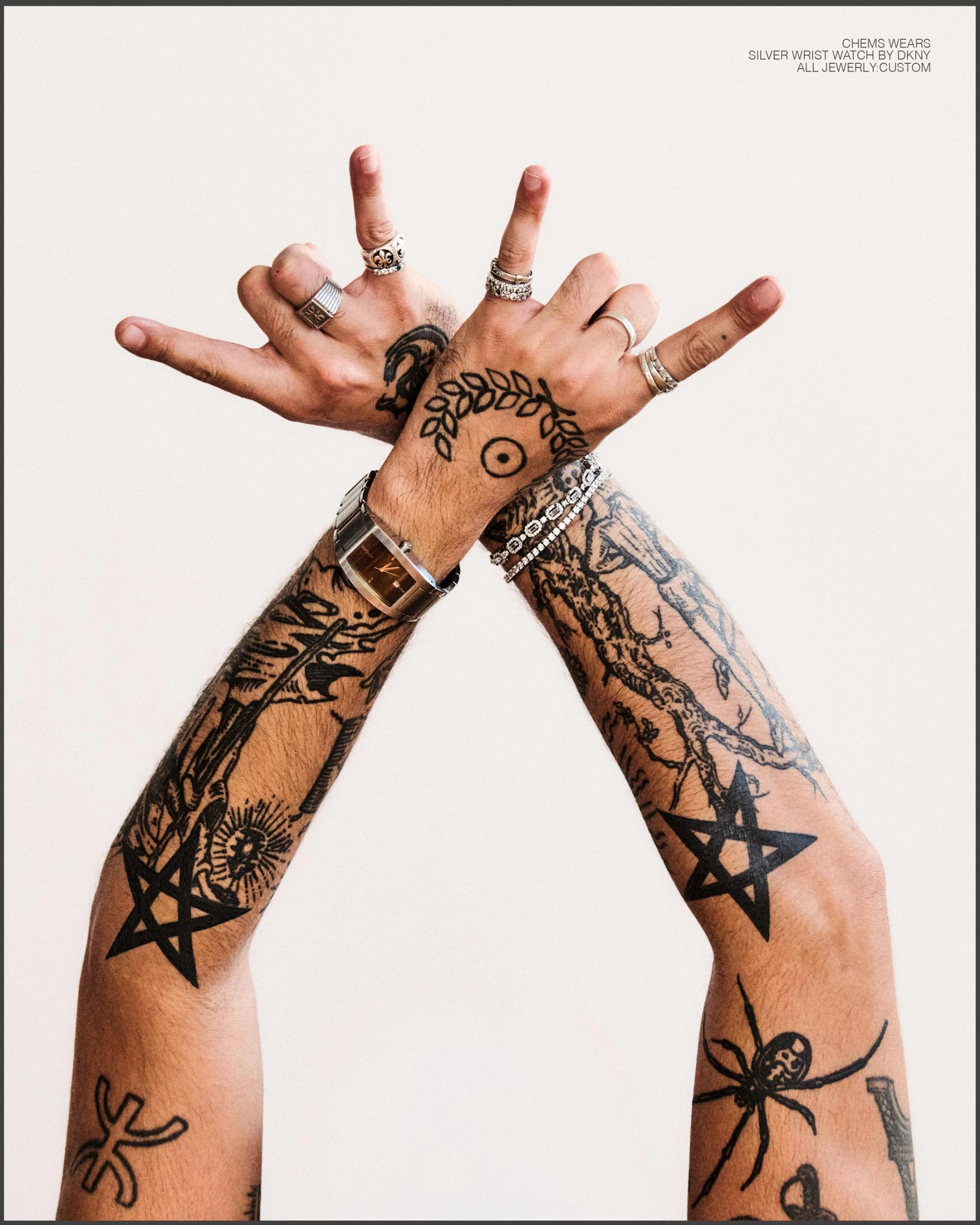 Crossed hands, tattoos and watch.