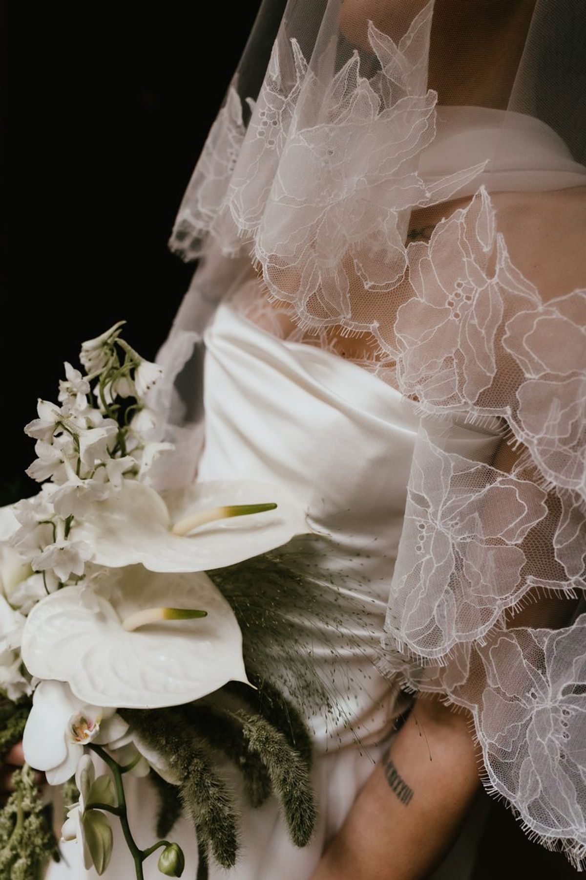 Close-up of cascading bouquet with lace veil detail