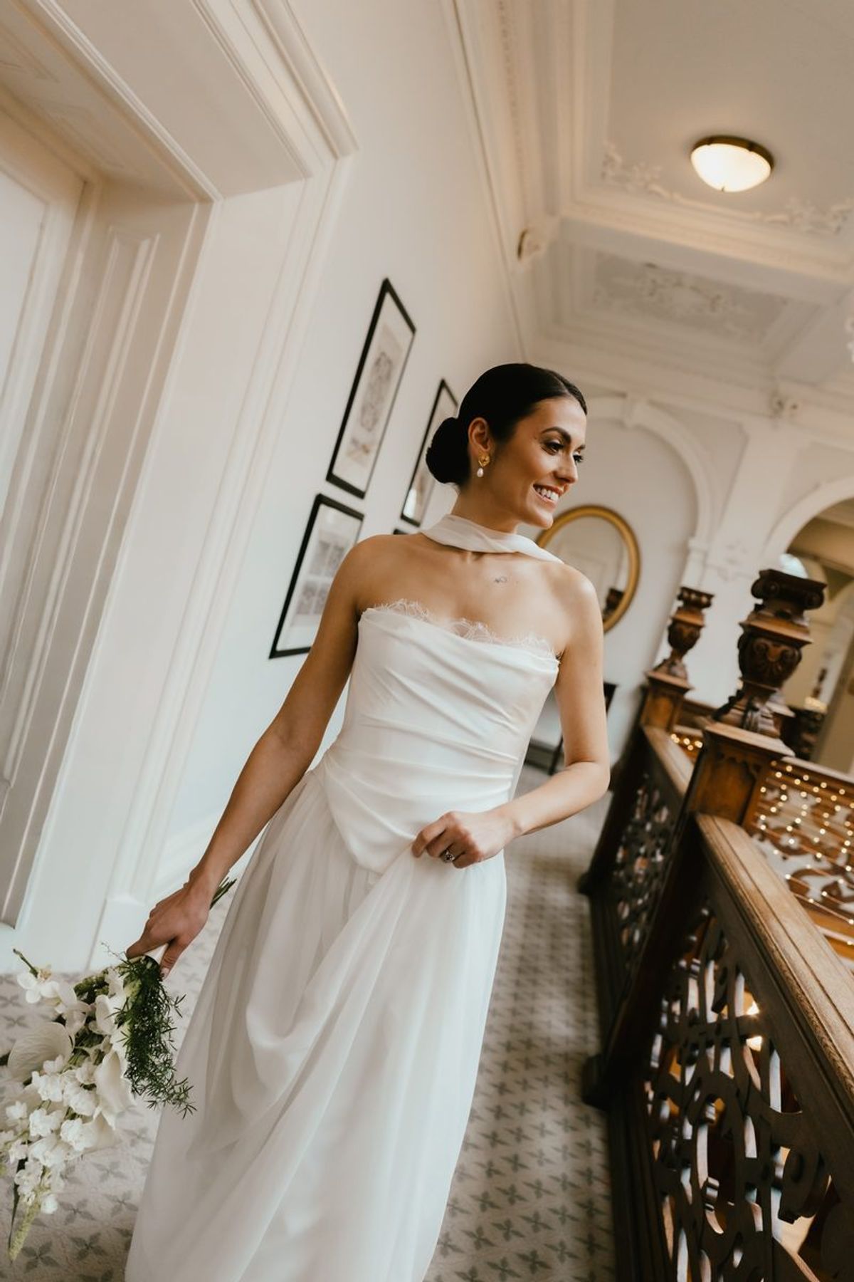 Bride descending grand staircase with bouquet