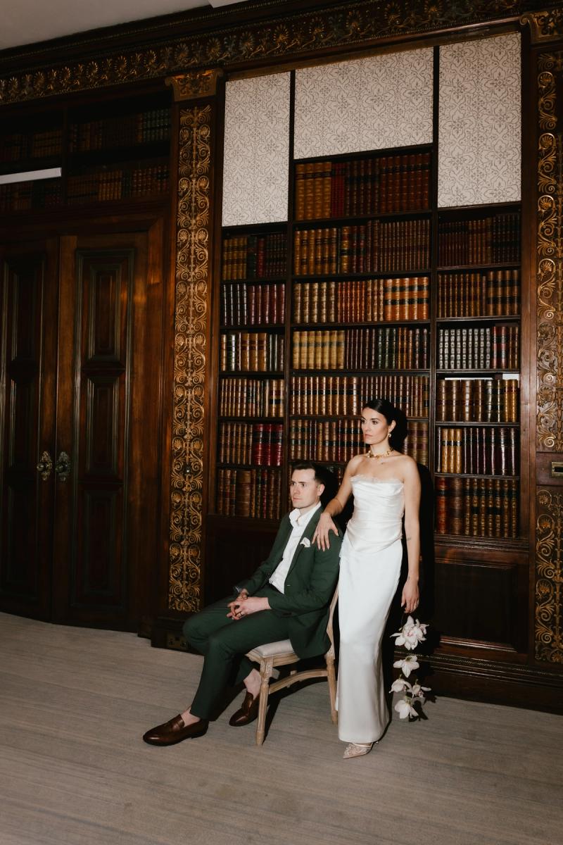 Bride and groom in library setting, bride wearing a sleek fitted bridal separate
