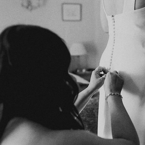 Laura, bridal designer, working intently on a wedding dress in her Bristol studio, showcasing expert craftsmanship