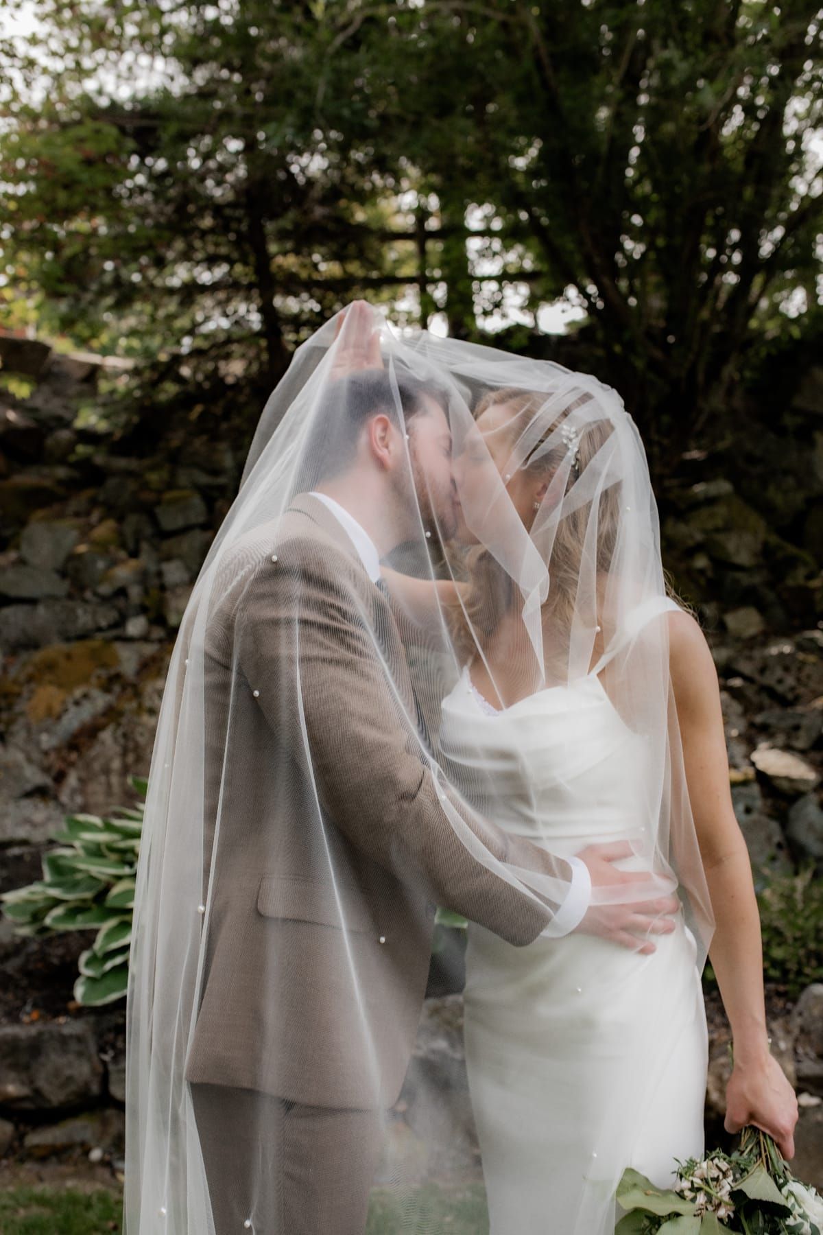 Romantic kiss under flowing wedding veil