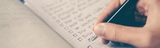 person writing bucket list on book