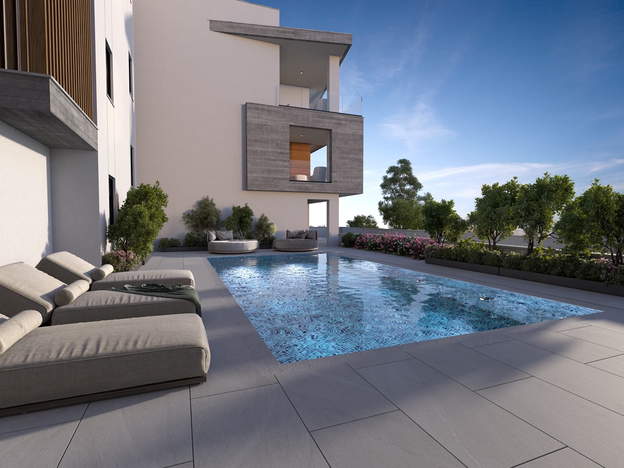 Communal swimming pool surrounded by trees and garden seating