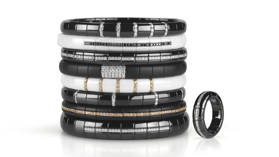 stack of black and white bracelets with precious stones