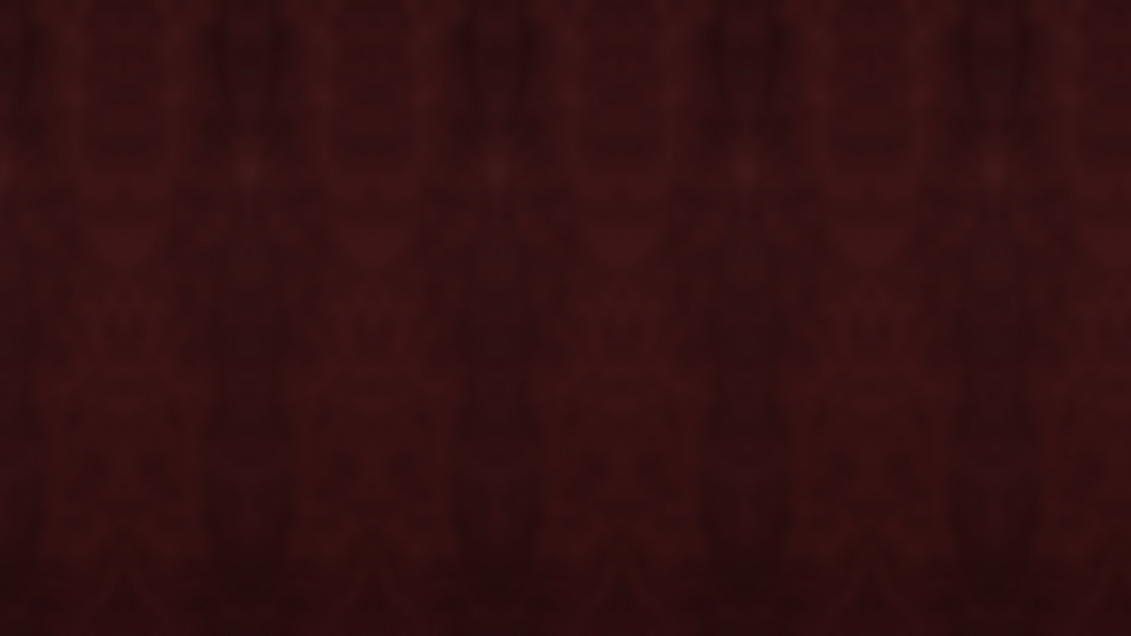Folds of a deep burgundy velvet backdrop