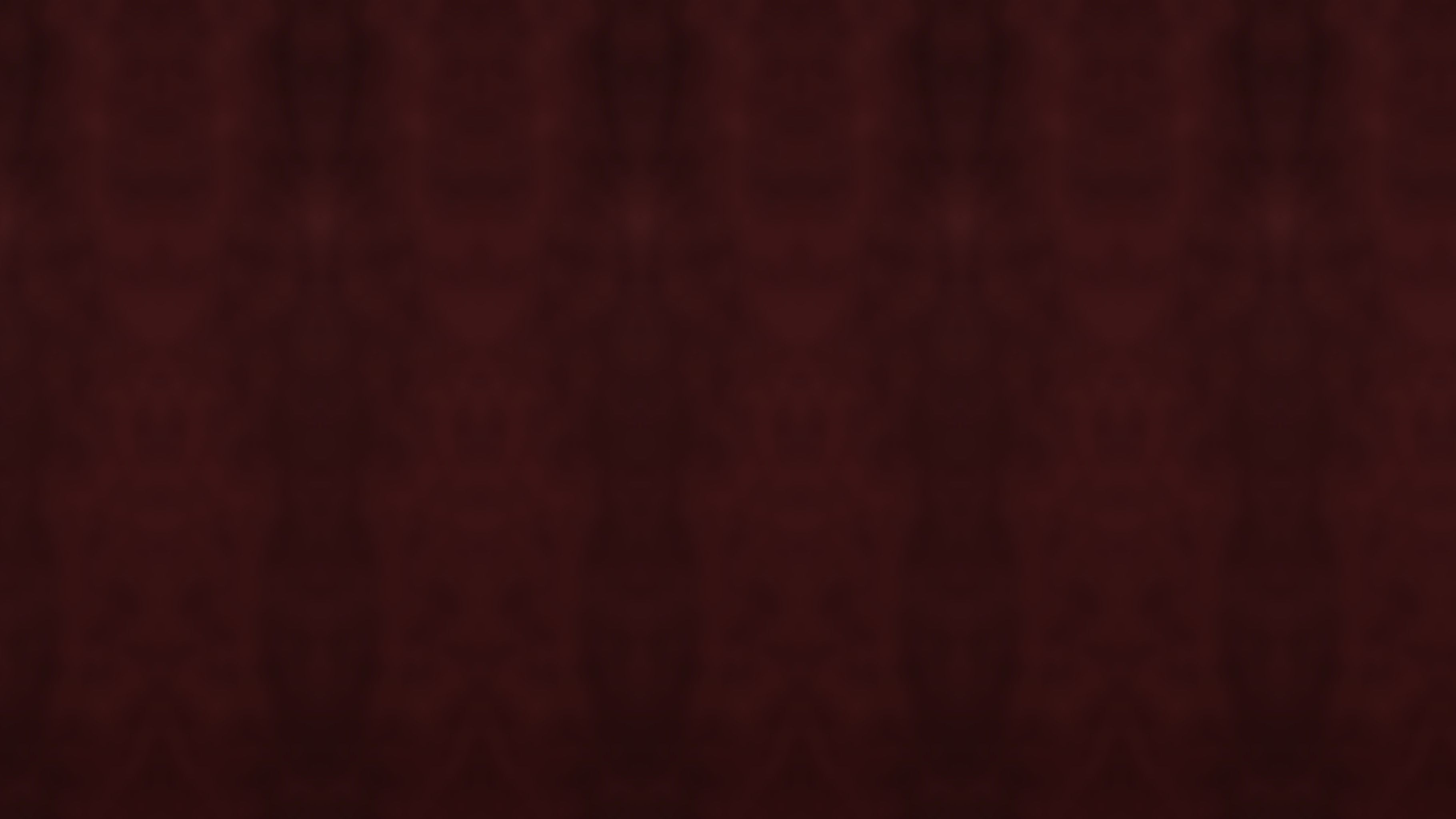 Folds of a deep burgundy velvet backdrop