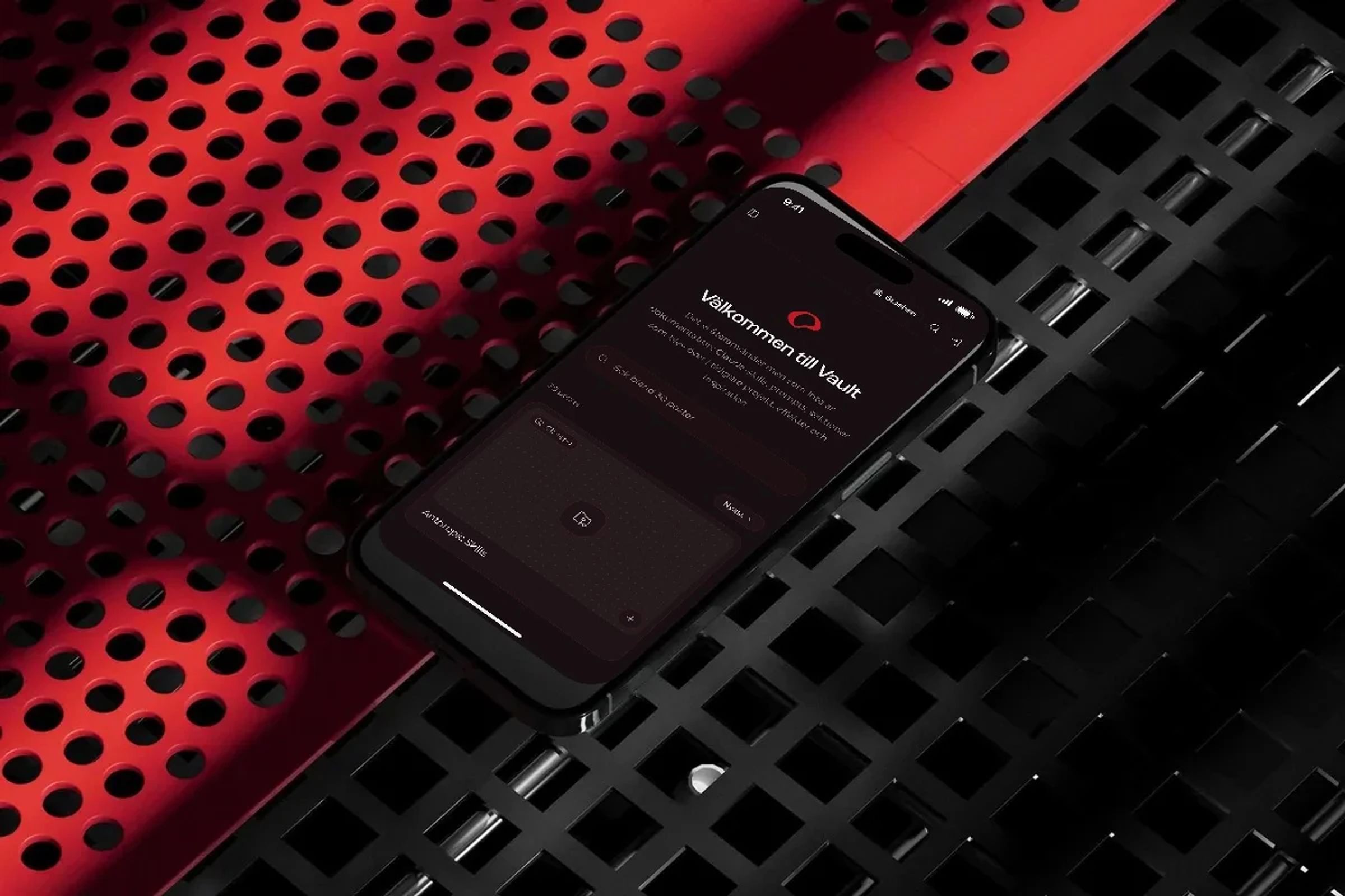 The Vault on an iPhone resting on a perforated metal grid in red light