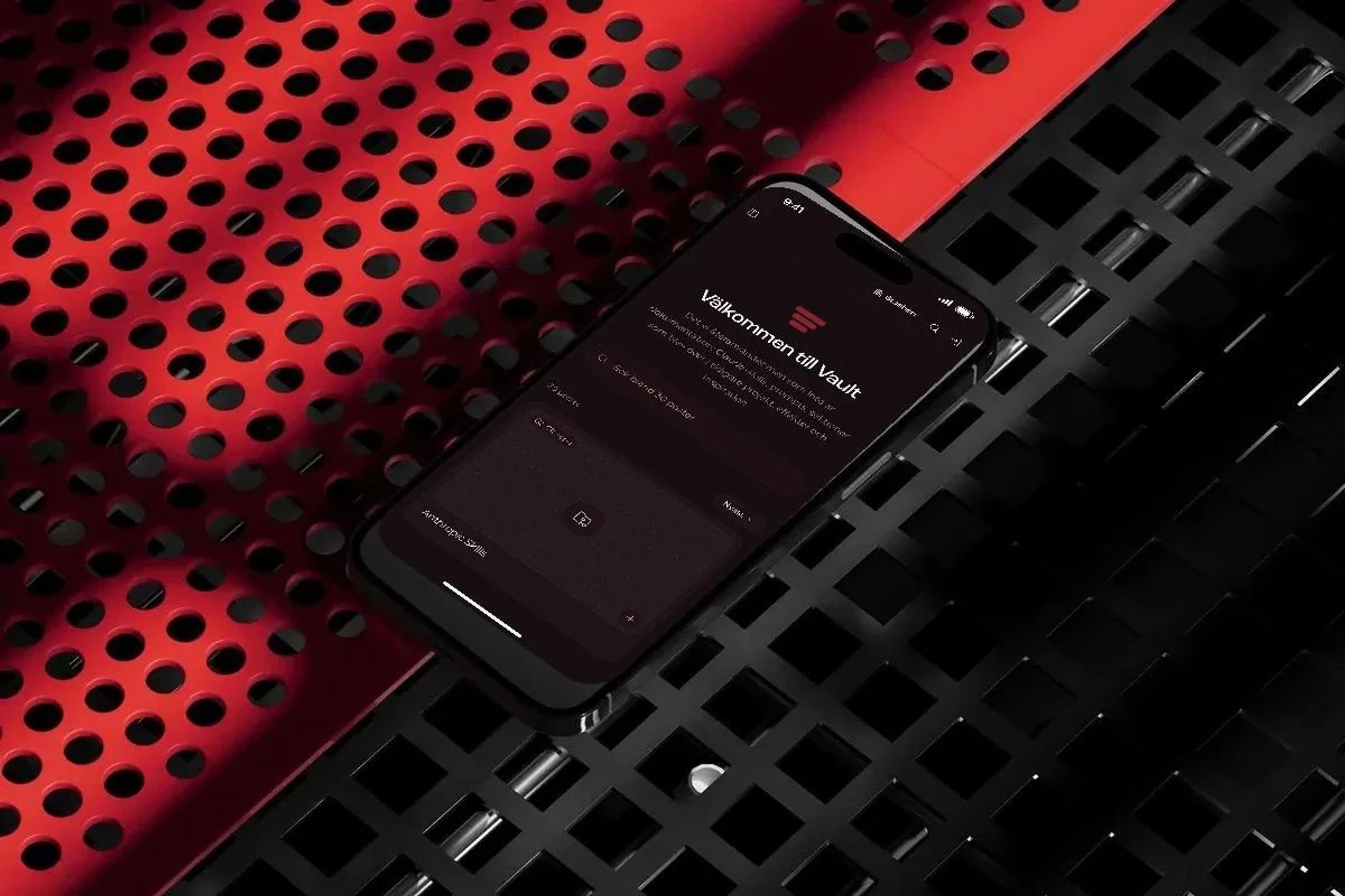 The Vault on an iPhone resting on a perforated metal grid in red light