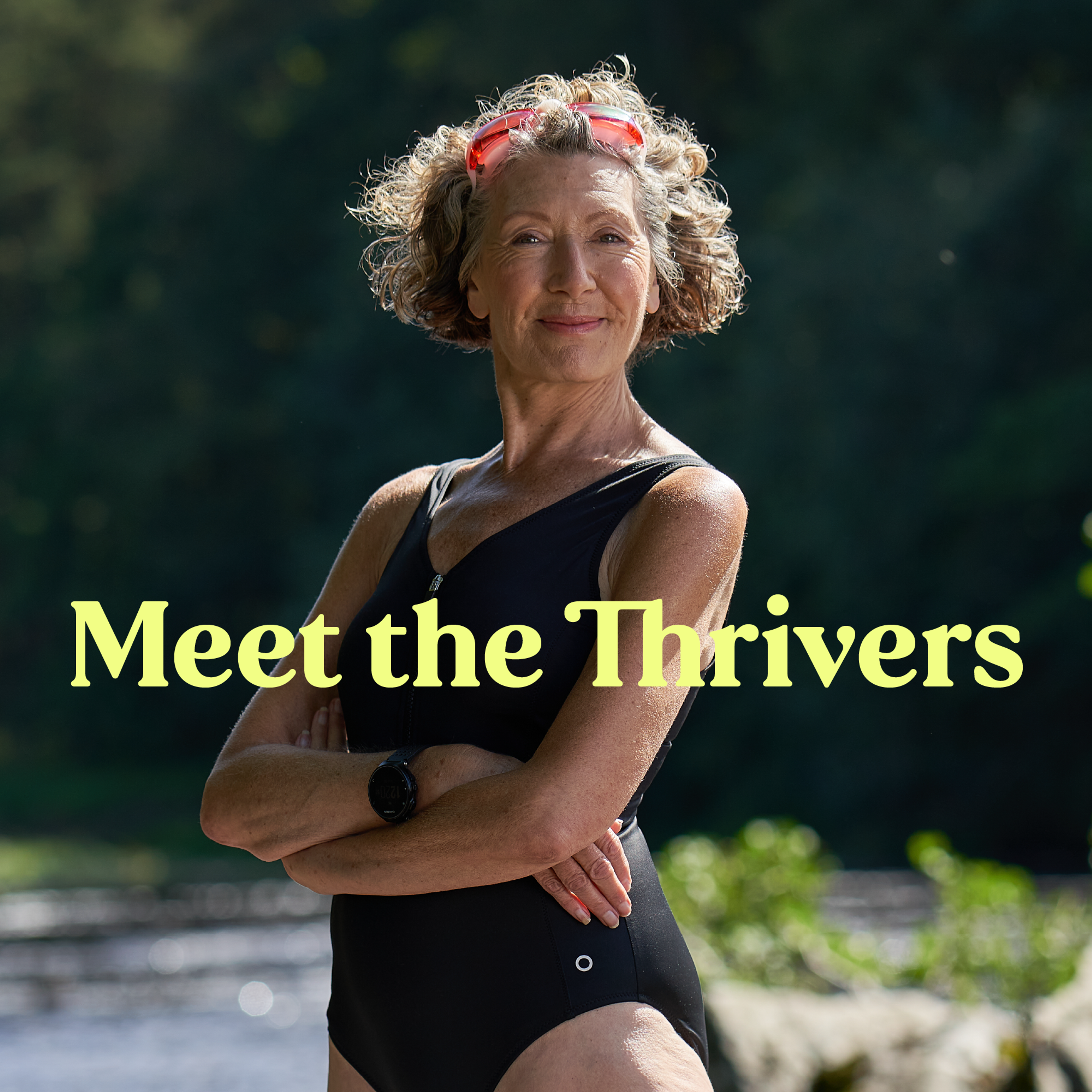 An elderly woman stands proudly river side in her swimming costume, with pink goggle strapped to her head. Light yellow text run across her saying "Meet the Thrivers"