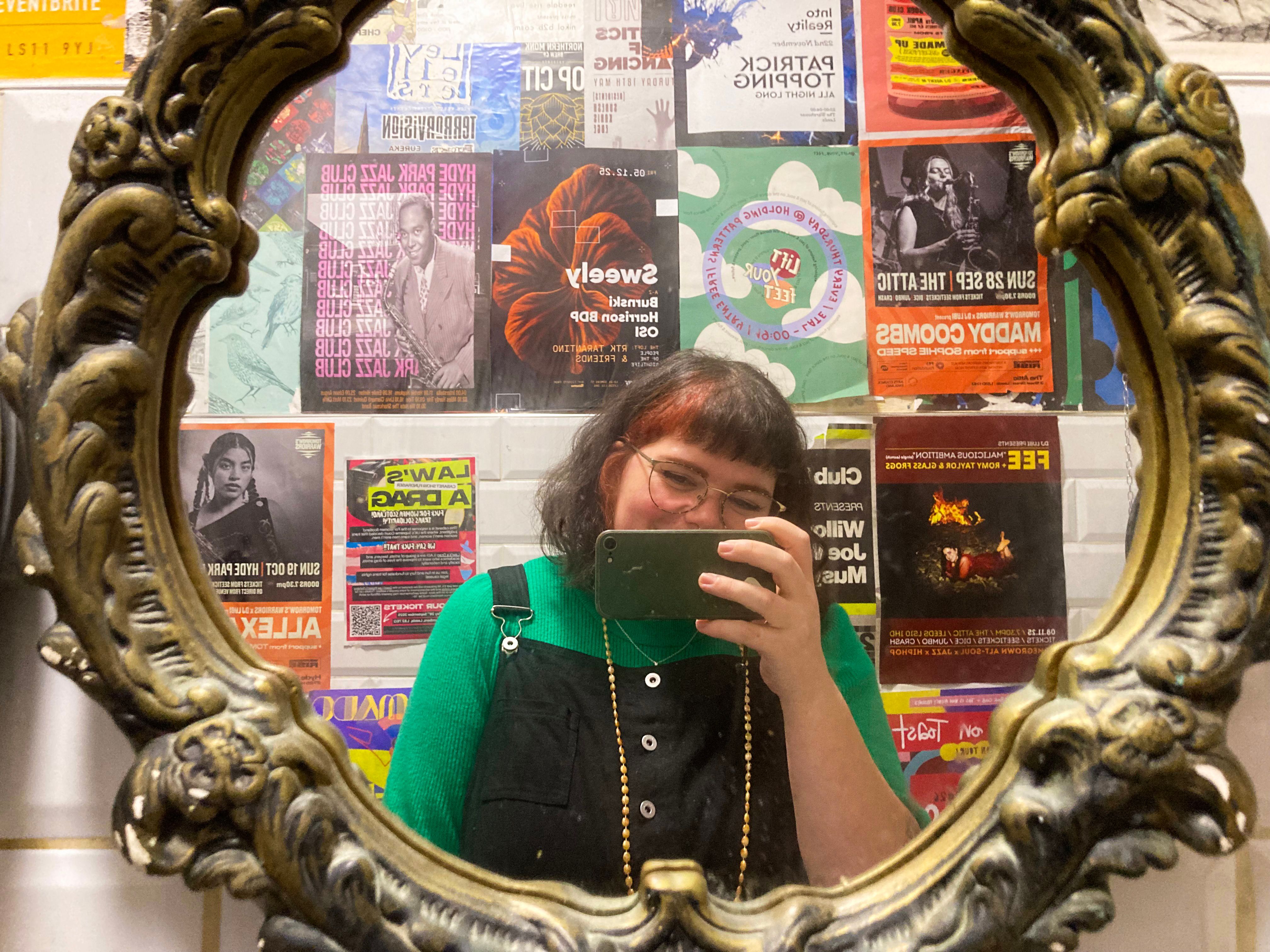 Image taken in a bathroom filled with event posters