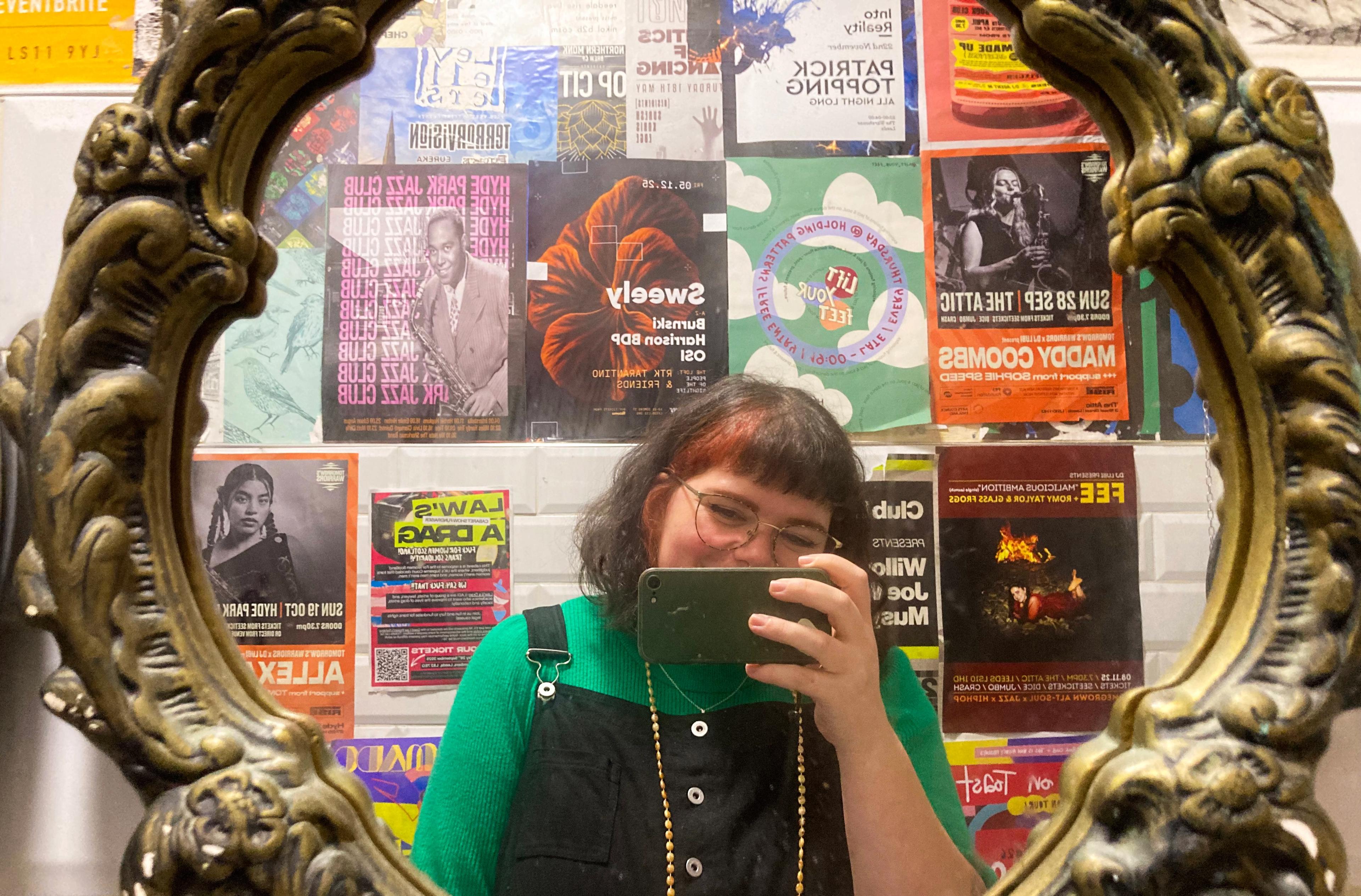 Image taken in a bathroom filled with event posters