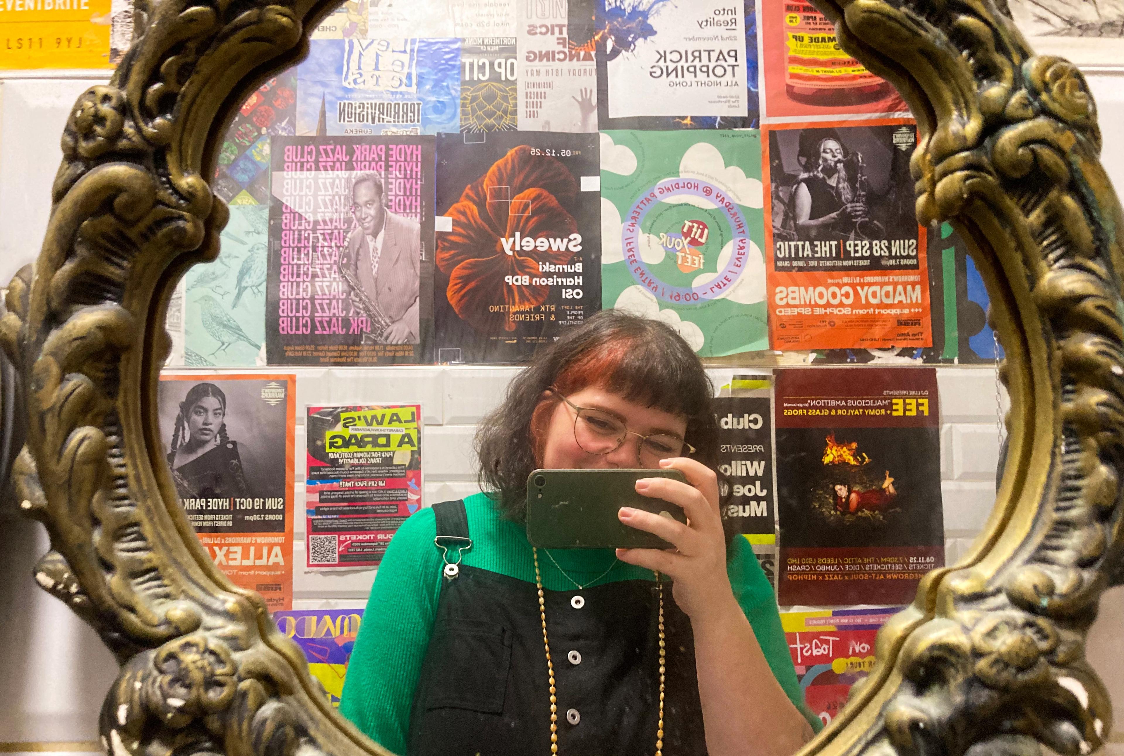 Image taken in a bathroom filled with event posters