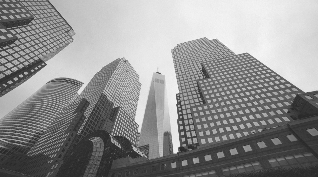 Black and white photo of modern skyscrapers viewed from below.