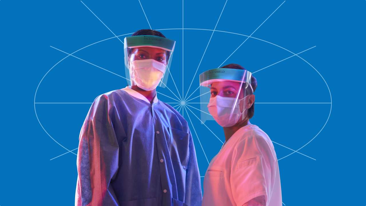 Two healthcare workers wearing face shields and masks, standing against a blue background with geometric lines.