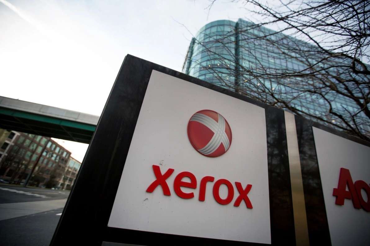 Xerox logo on an outdoor sign with a building in the background.