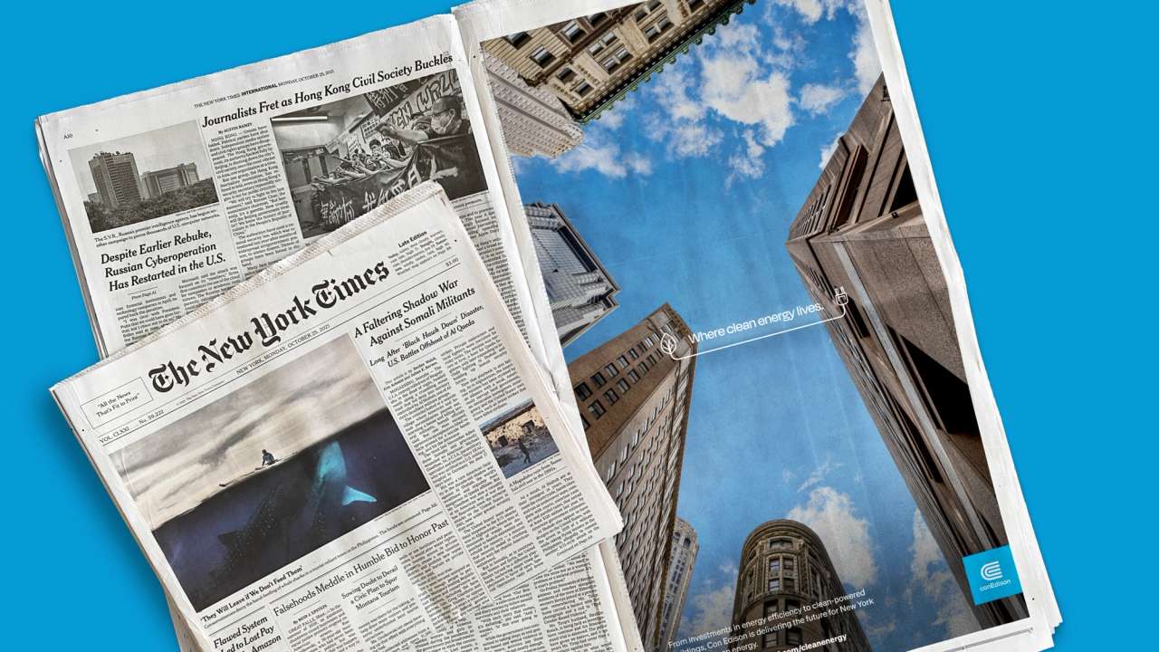 New York Times newspapers with a ConEdison ad featuring skyscrapers and a blue sky.