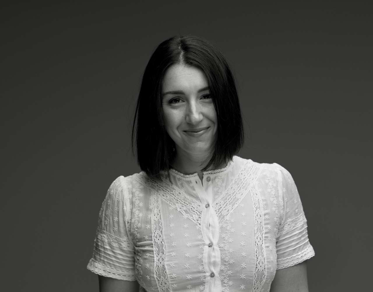 Portrait of a person in a white blouse.