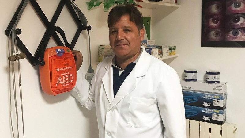 Il cardiologo Giorgio Ventura accanto a un defibrillatore DAE nella sua struttura