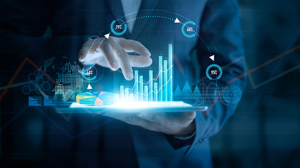 Man in a suit holding a tablet with graphics of graphs and charts coming out of it