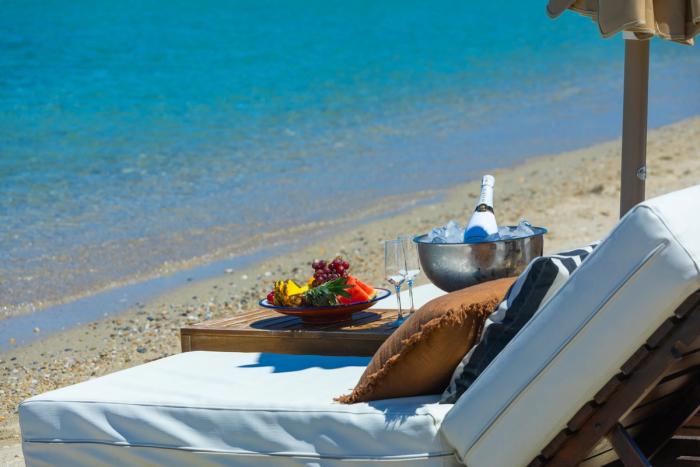 Luxury beach setup with umbrella and refreshments